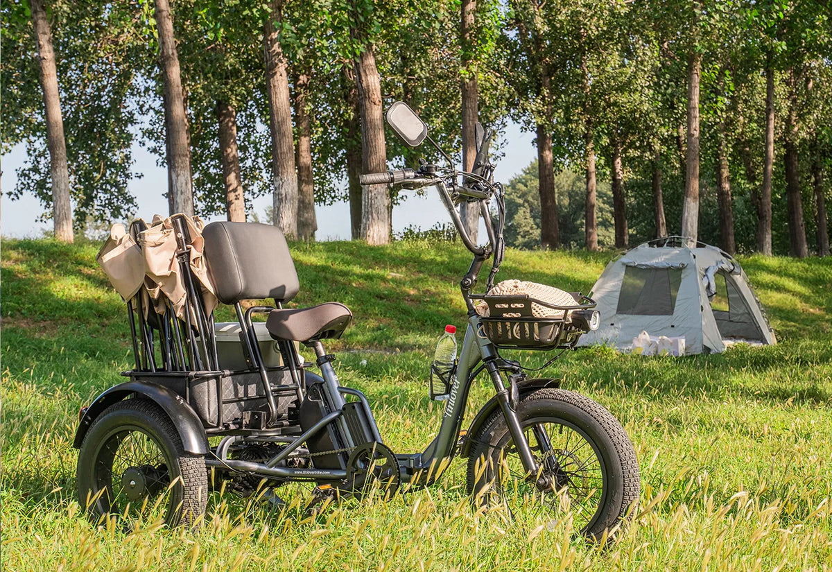 Tiniover Creek Pro electric trike with rear baskets and camping gear beside a tent