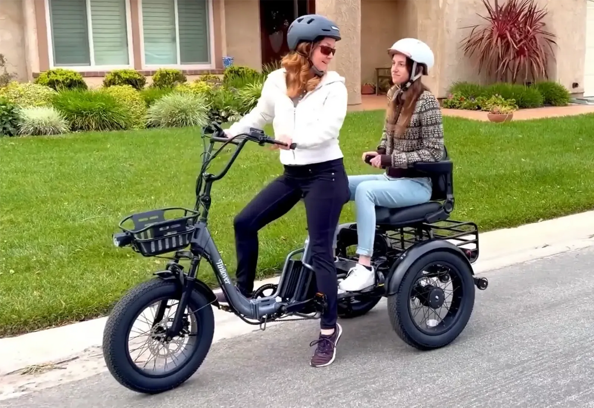 Tiniover Creek Pro electric trike carrying a passenger on a residential street